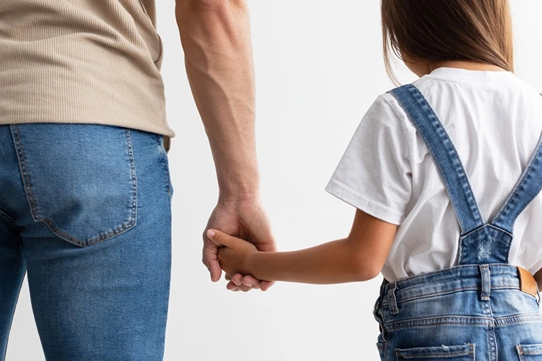 Cropped close up of man and girl holding hands, enjoying spending free time together