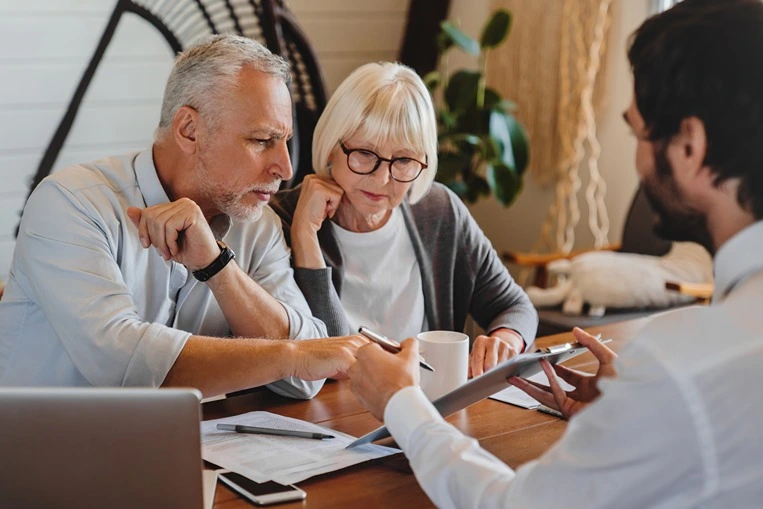 A Frisco retirement and pension plan division lawyer going over assets with an older couple.