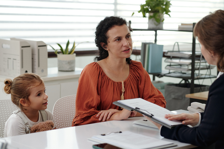 Woman discussing contract sitting next to her child - how to prepare for your Texas custody suit